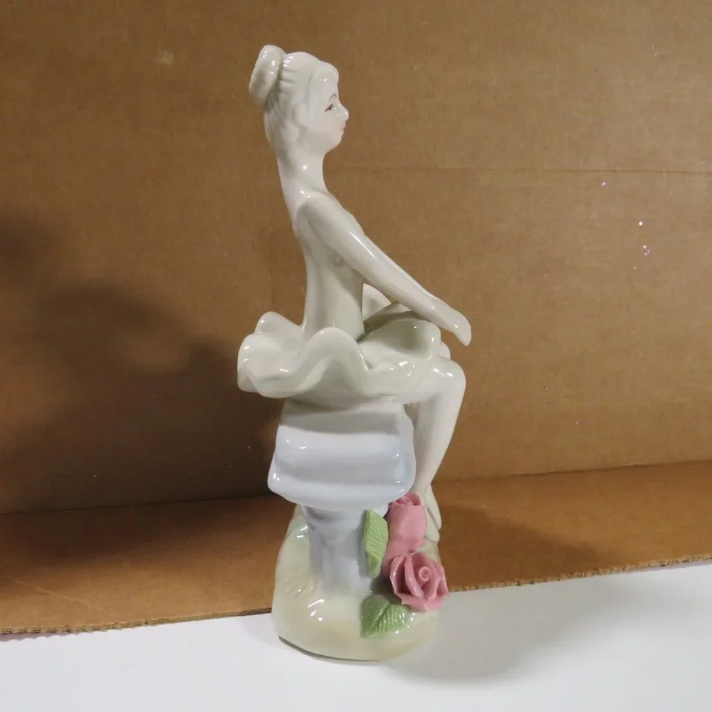 Ceramic Ballerina Figure sitting on bench with Roses